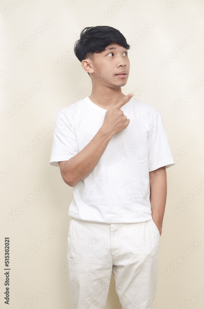portrait of handsome asian young man smiling while looking sideways in empty space portrait of handsome asian young man smiling while looking sideways in empty space