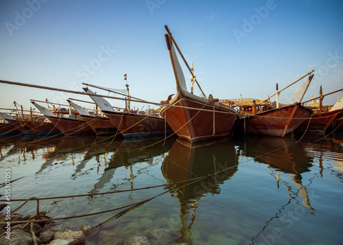 Kuwait fish port with old wood fishing boat and reflection 