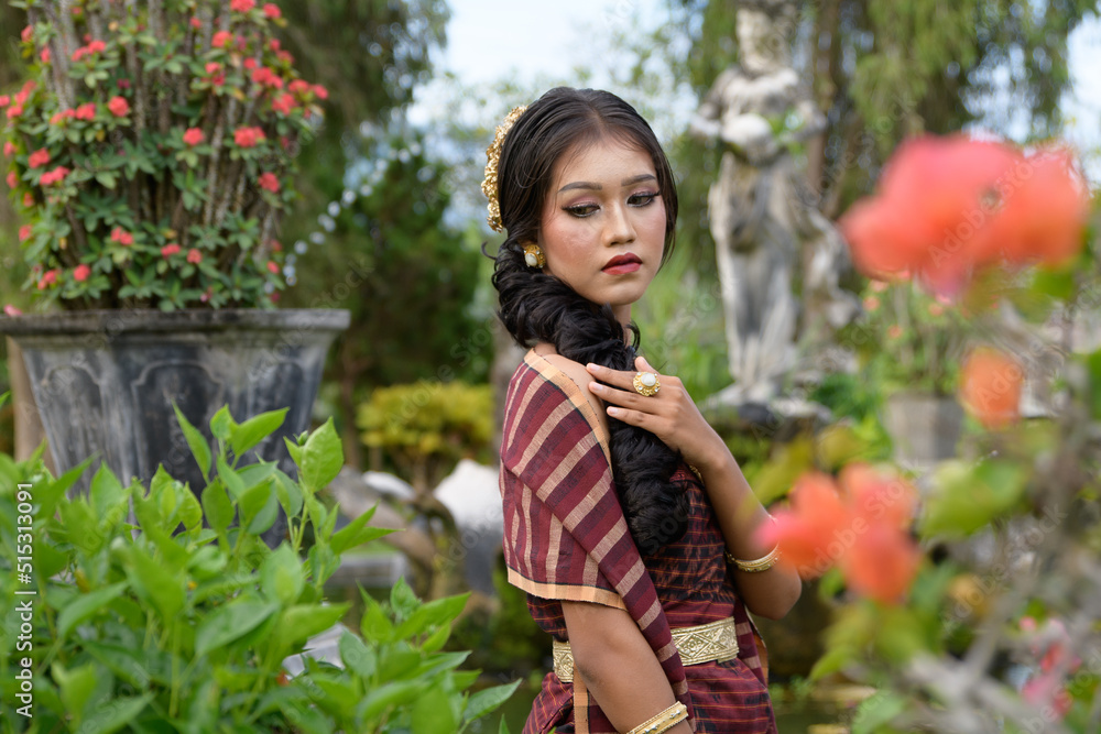 Beautiful girl in Balinese traditional dress with fan, Taman Ujung Bali. Beautiful girl in Balinese traditional dress with fan, Taman Ujung Bali.