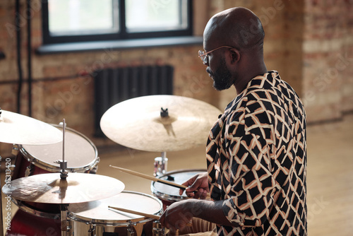 Canvas-taulu African american drummer learning to play drums with sticks at musical studio