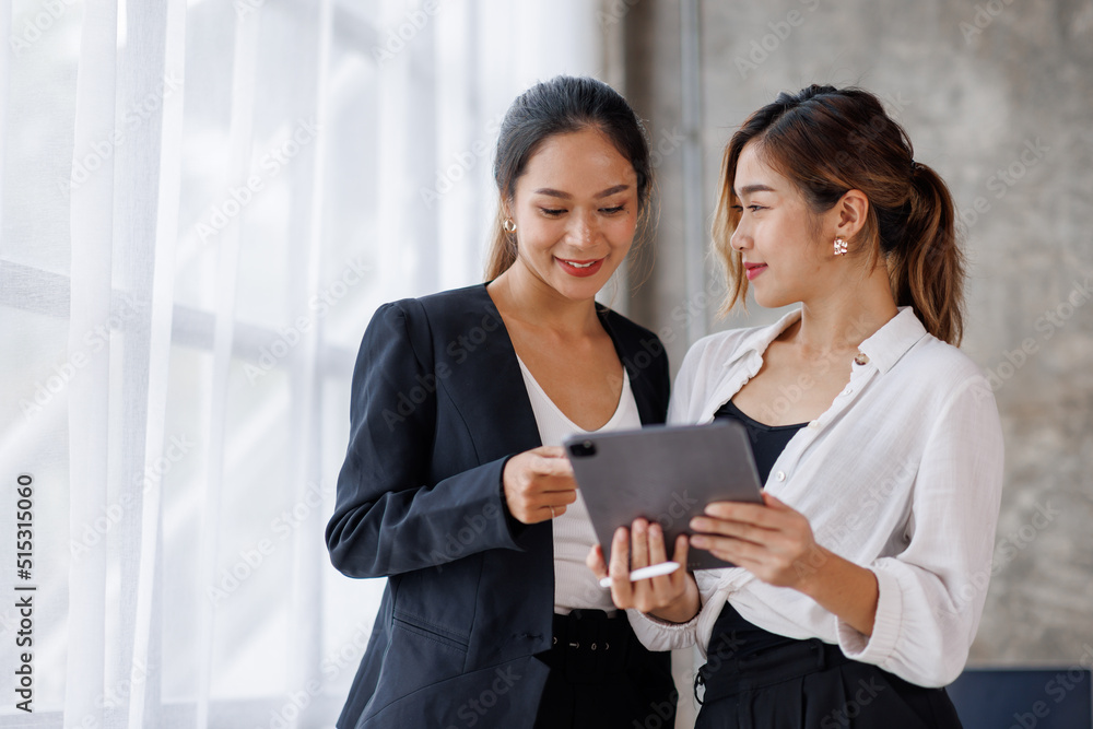 Businesswoman executive is using a tablet in meeting discussion with another businesswoman or client in modern workplace office. People corporate Asian business people team concept. Businesswoman executive is using a tablet in meeting discussion with another businesswoman or client in modern workplace office. People corporate Asian business people team concept.