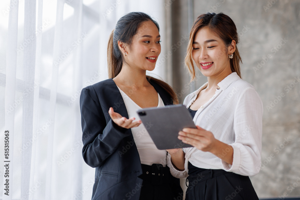 Businesswoman executive is using a tablet in meeting discussion with another businesswoman or client in modern workplace office. People corporate Asian business people team concept. Businesswoman executive is using a tablet in meeting discussion with another businesswoman or client in modern workplace office. People corporate Asian business people team concept.