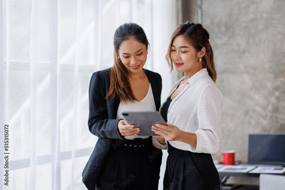 Obraz premium Businesswoman executive is using a tablet in meeting discussion with another businesswoman or client in modern workplace office. People corporate Asian business people team concept.