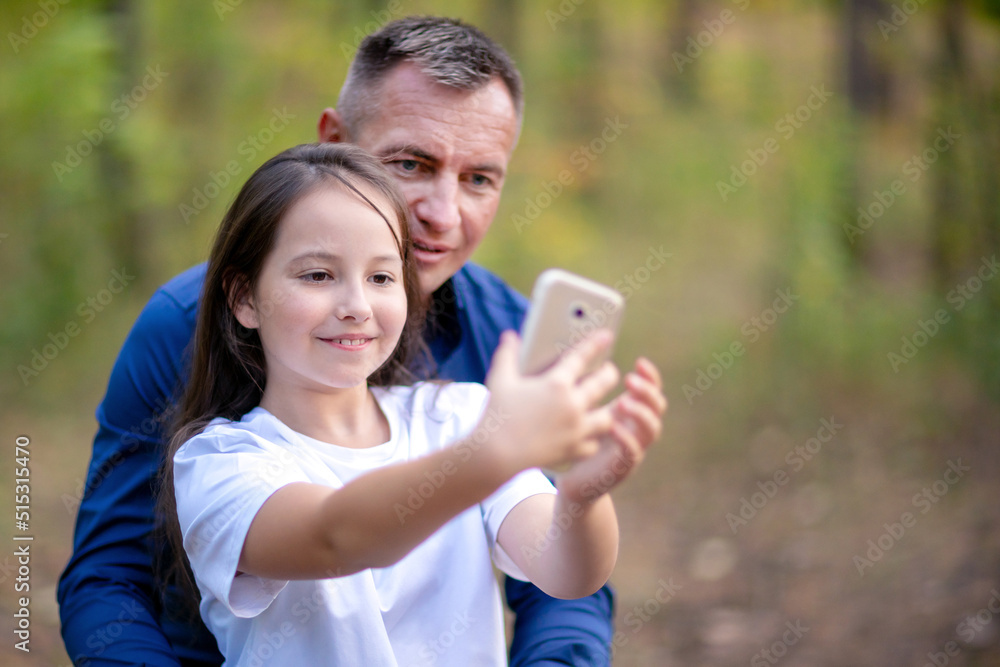 Father and daughter taking selfie on smartphone outdoors Father and daughter taking selfie on smartphone outdoors