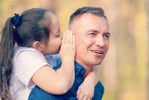 Little girl whispering in father ear © watman