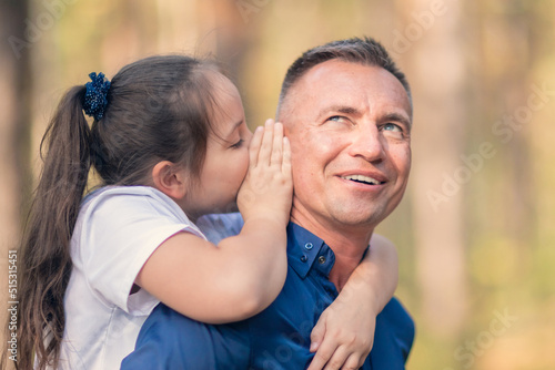 Little girl whispering in father ear © watman
