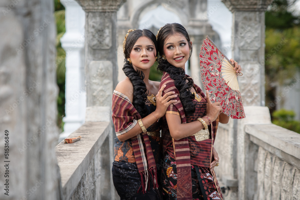 Beautiful girls in Balinese traditional dress with fan, Taman Ujung Bali.