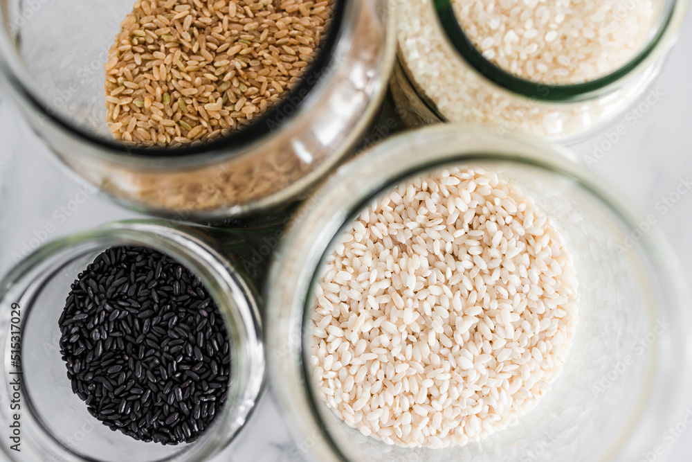 pantry jars with different types of rice including black brown arborio