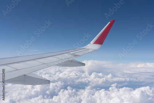 view of white clouds in the sky from the window of an airplane over the wing