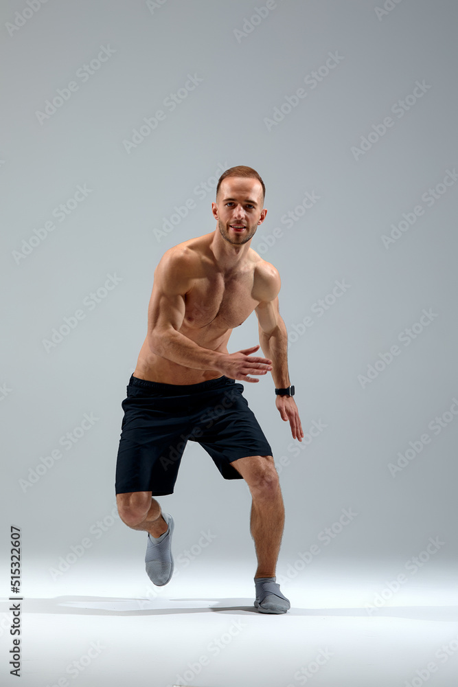 Developing endurance. Male athlete in motion isolated over gray studio background. Maintaining health and strength. Concept of sport, healthy lifestyle, motion Developing endurance. Male athlete in motion isolated over gray studio background. Maintaining health and strength. Concept of sport, healthy lifestyle, motion