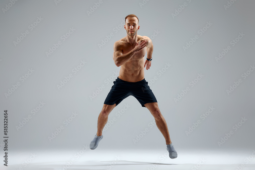 Developing endurance. Male athlete in motion isolated over gray studio background. Maintaining health and strength. Concept of sport, healthy lifestyle, motion Developing endurance. Male athlete in motion isolated over gray studio background. Maintaining health and strength. Concept of sport, healthy lifestyle, motion