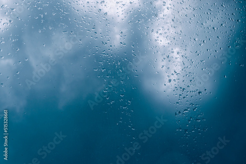 Drops of rain on the window against storm clouds.