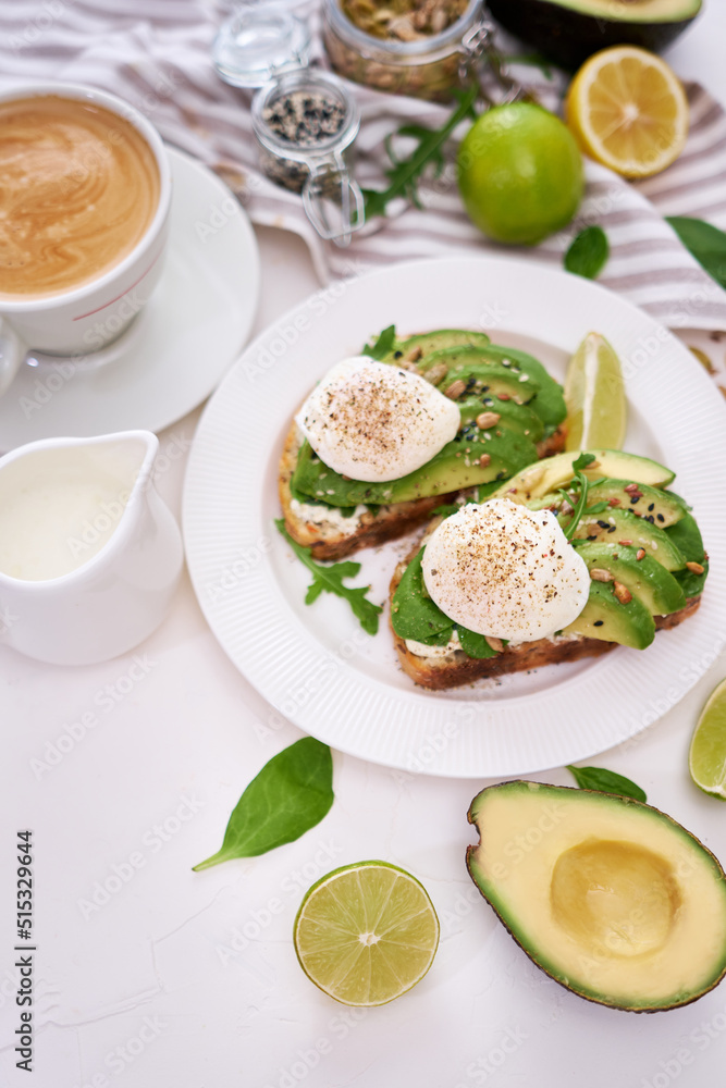 Freshly made poached egg and Avocado toasts on light grey background Freshly made poached egg and Avocado toasts on light grey background