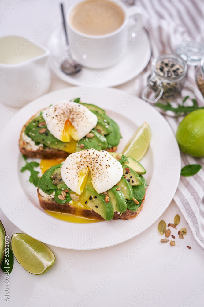 Freshly made poached egg and Avocado toasts on light grey background Freshly made poached egg and Avocado toasts on light grey background