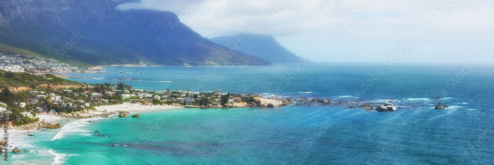 A peaceful view of the Clifton ocean at the Atlantic seaboard with an island and mountains in the background. A city surrounded by blue fresh water and a foggy cloudy sky with copy space. A peaceful view of the Clifton ocean at the Atlantic seaboard with an island and mountains in the background. A city surrounded by blue fresh water and a foggy cloudy sky with copy space.