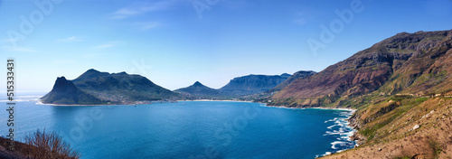 Top landscape view of ocean surrounded by mountains in Hout Bay in Cape Town, South Africa. Popular tourist attraction of hills and calm blue water from above. Exploring nature and the wild