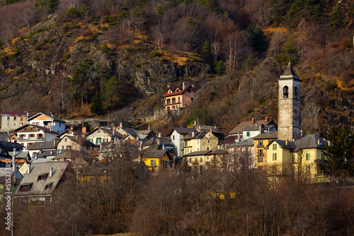 View of residential houses and parish church belfry in small Alpine hamlet of Finero located in Cannobina valley on winter day, Piedmont, Italy photo