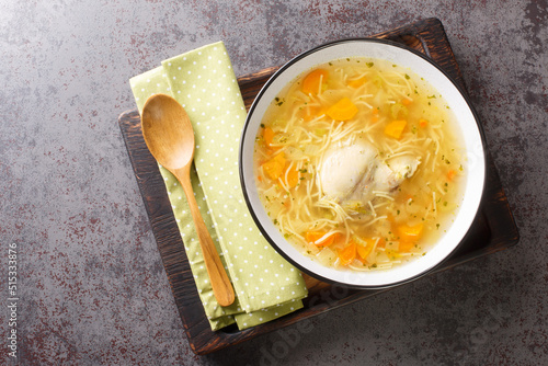 Cuadro en lienzo Polish Rosol z kury chicken soup with vermicelli and vegetables close-up in a bowl on a wooden tray on the table