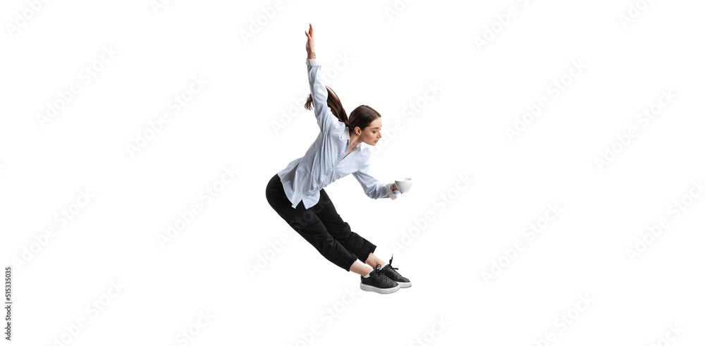 Portrait of young woman, office employee in official suit drinking coffee in a jump isolated over white background