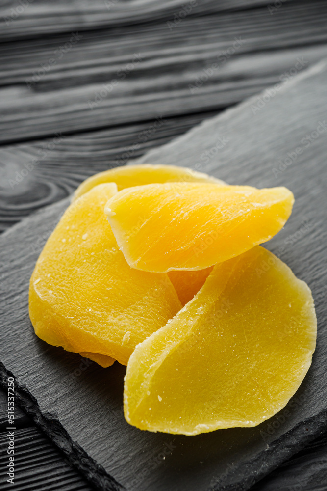 delicious dried mango on a black wooden rustic background delicious dried mango on a black wooden rustic background