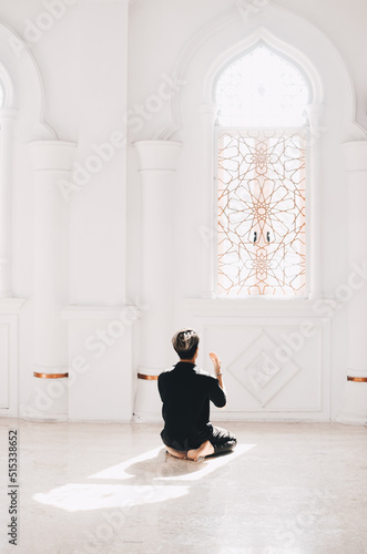 young man praying in the mosque asking God for forgiveness