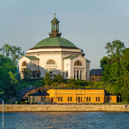 Eric Ericsonhallen concert hall, formerly Skeppsholmen Church until 2009, surrounded by trees. View from Stockholms strom in a sunny summer day, Stockholm, Sweden photo