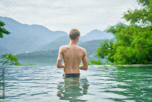 Diabetes patient in a swimmingpool with an waterproof CGM (Continuous Glucose Monitor) device to measure real-time blood sugar for a healthy lifestyle without setbacks for a good healthcare.