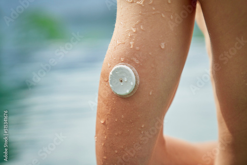 Diabetes patient in a swimmingpool with an waterproof CGM (Continuous Glucose Monitor) device to measure real-time blood sugar for a healthy lifestyle without setbacks for a good healthcare.