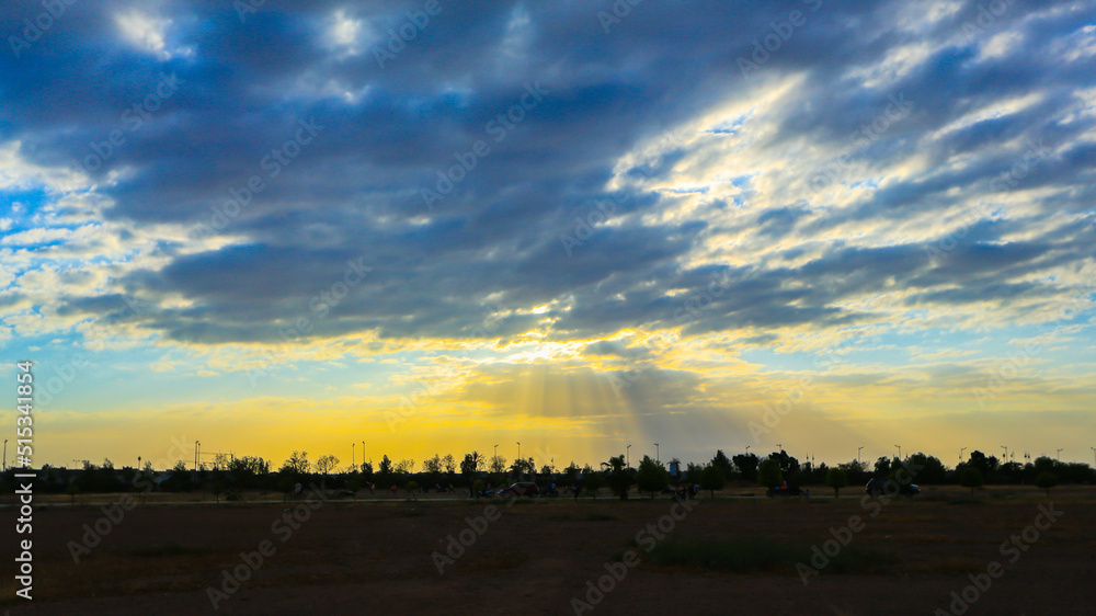 Yellow sun rays from grey clouds