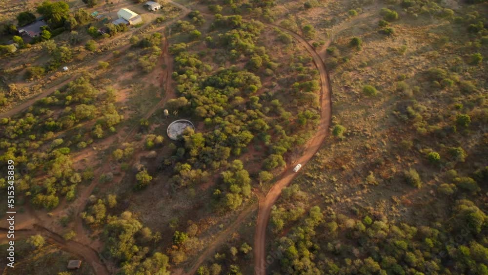 Birds eye view of car driving on unpaved roads of mixed woodland and grassland of savannah. Aerial. Birds eye view of car driving on unpaved roads of mixed woodland and grassland of savannah. Aerial.