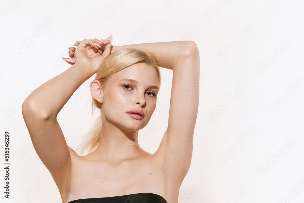 Obraz premium Young beautiful girl with blond glossy hair and without makeup isolated on white studio background. Spa, cosmetics, wellbeing and skin care concept