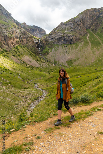 A young woman next to the Salto de Tendenera Waterfall in the Ripera Valley, Panticosa, Pyrenees photo