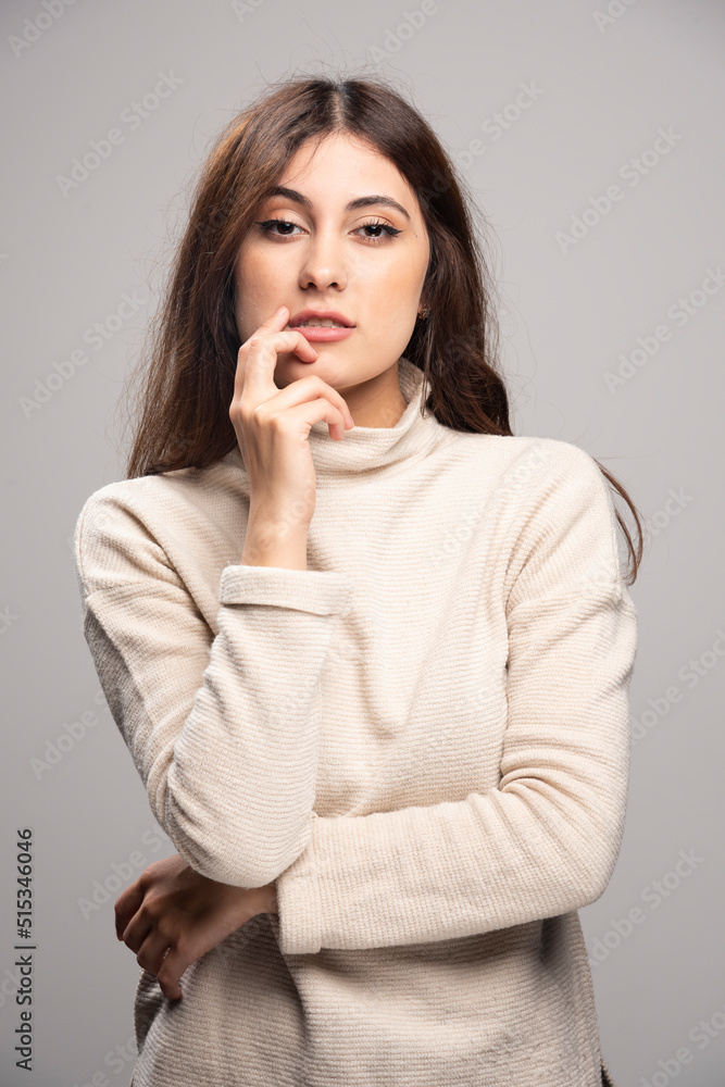 Portrait of a young woman posing on a gray wall Portrait of a young woman posing on a gray wall