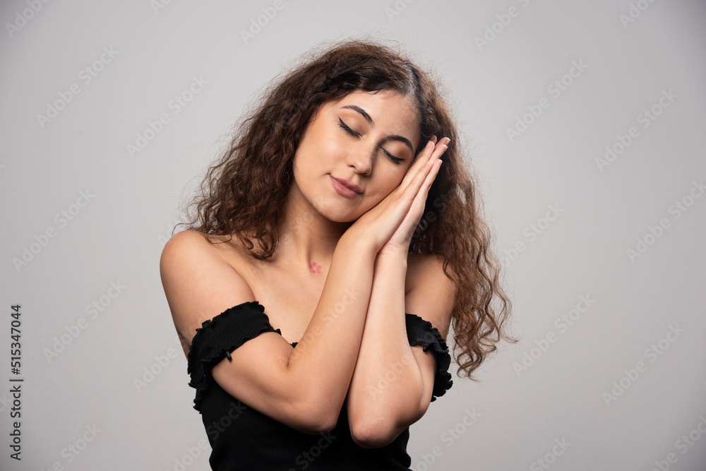 Young woman in black blouse with curly hair posing