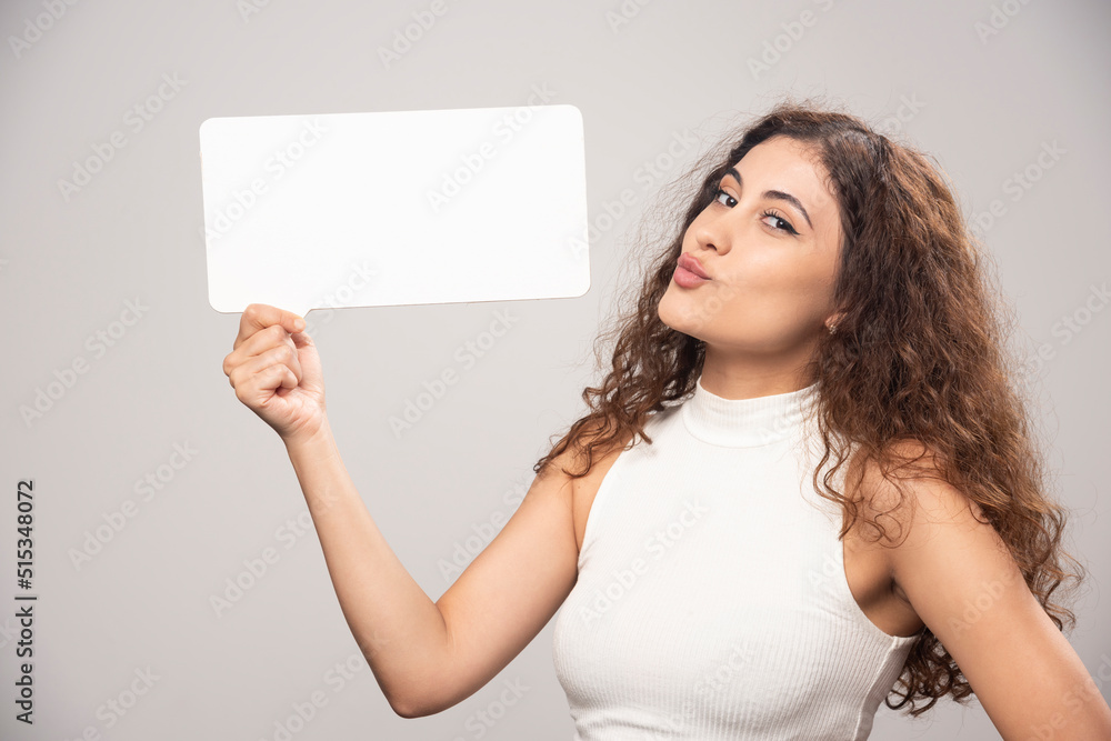 Young woman holding empty blank white speech poster Young woman holding empty blank white speech poster