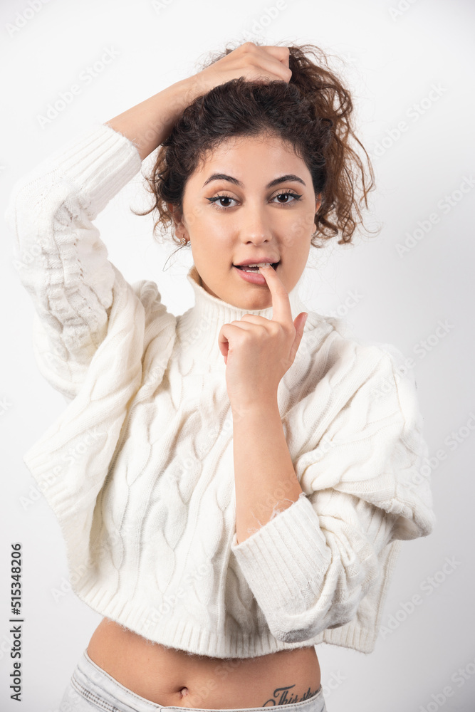 Young woman in white sweater standing over a white wall Young woman in white sweater standing over a white wall