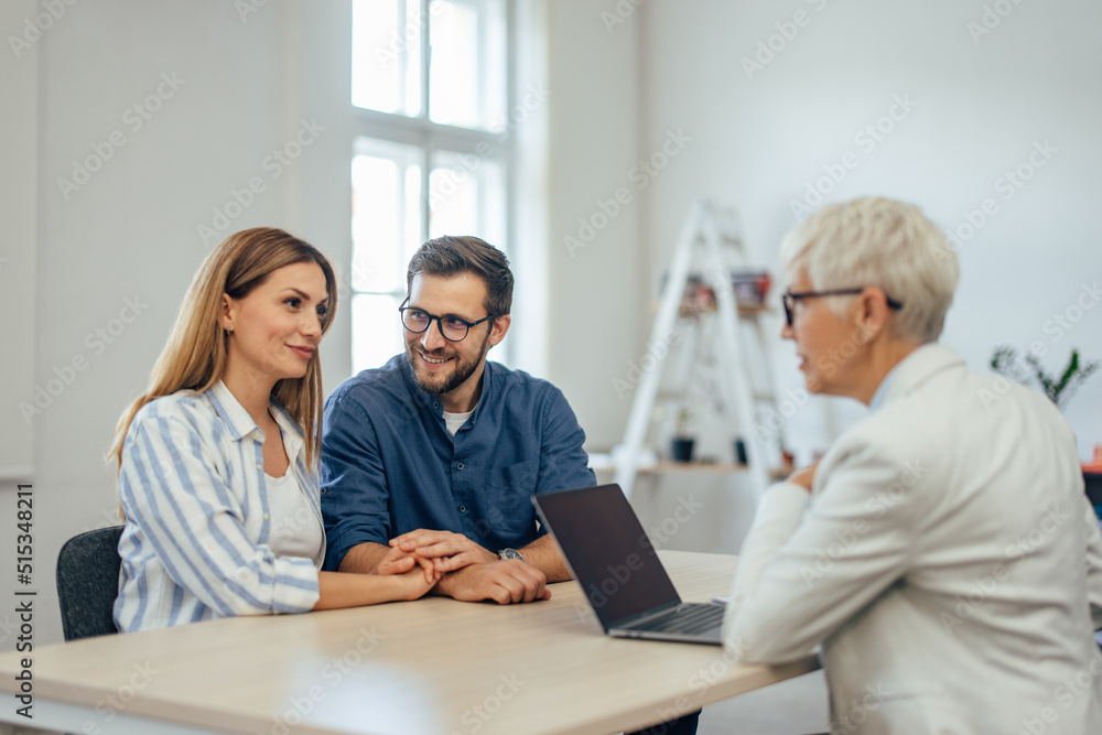 Positive adult couple consulting with an insurance agent. Positive adult couple consulting with an insurance agent.