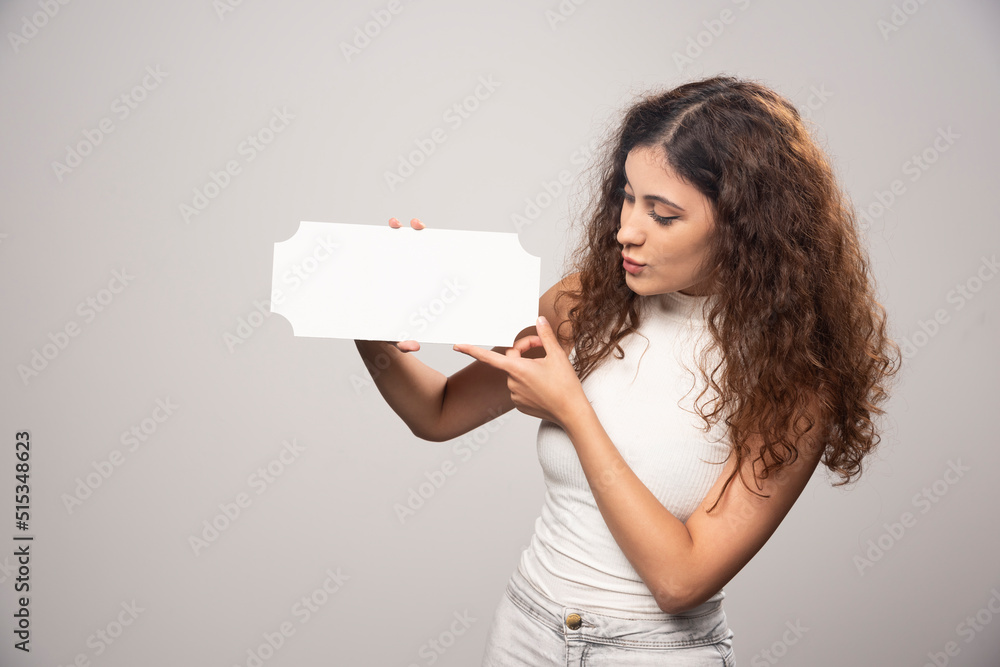 Young woman looking at an empty blank white speech poster Young woman looking at an empty blank white speech poster