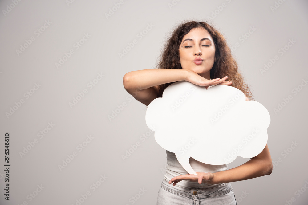 Young woman holding empty blank white speech bubble Young woman holding empty blank white speech bubble