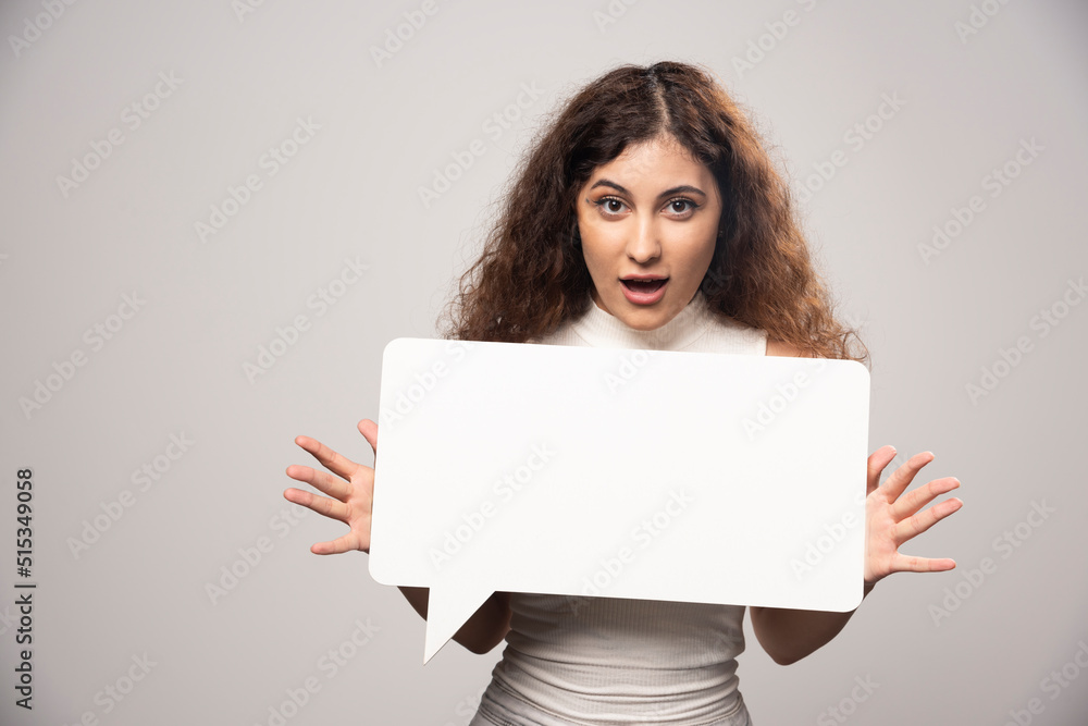 Young woman holding empty blank white speech poster Young woman holding empty blank white speech poster