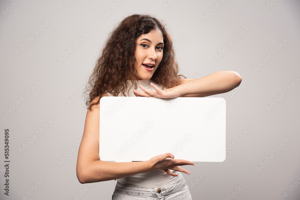 Young woman holding empty blank white speech poster Young woman holding empty blank white speech poster
