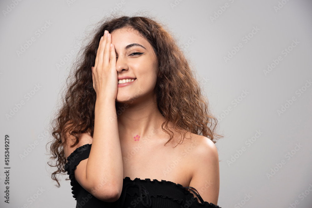 Young woman posing in black blouse with curly hair Young woman posing in black blouse with curly hair