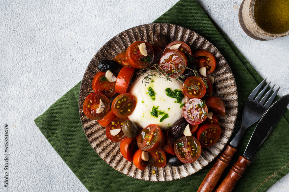 Italian caprese salad with sliced tomatoes, mozzarella, basil, olive oil on a light background. Top view. Healthy food. Italian salad