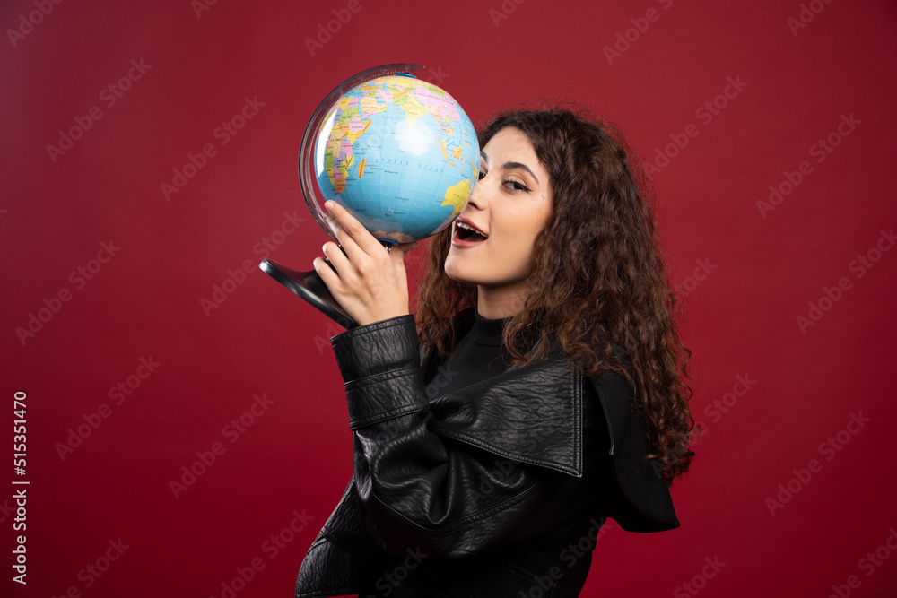 Young woman in all black outfit holding a globe