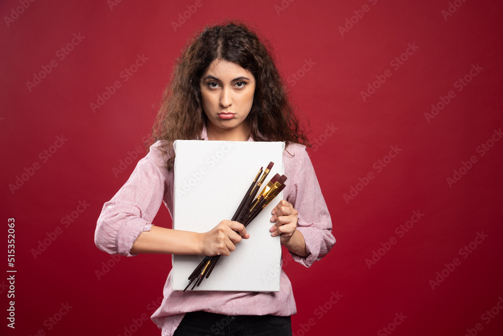 Young artist posing with paintbrushes and canvas Young artist posing with paintbrushes and canvas