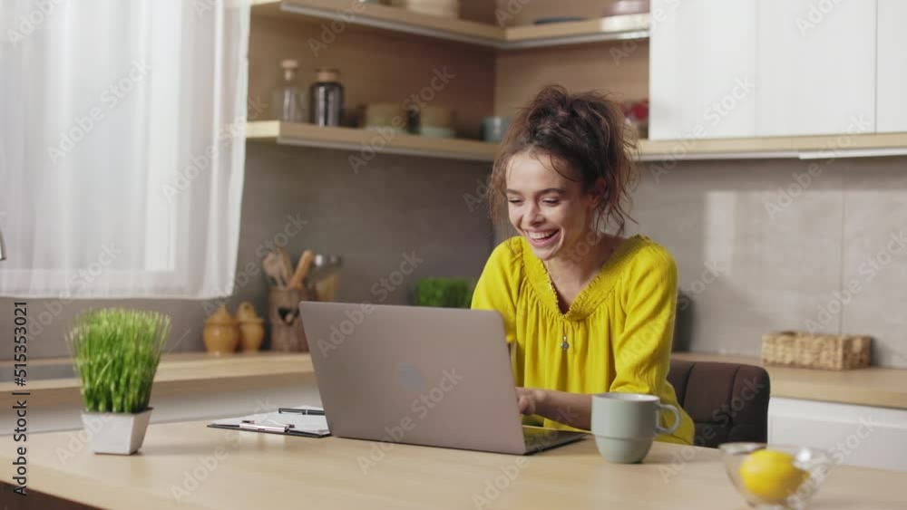 Caucasian young woman gesturing from happiness while reading good news on modern laptop. Joyful female freelance celebrating some success or achievement at work. Caucasian young woman gesturing from happiness while reading good news on modern laptop. Joyful female freelance celebrating some success or achievement at work.