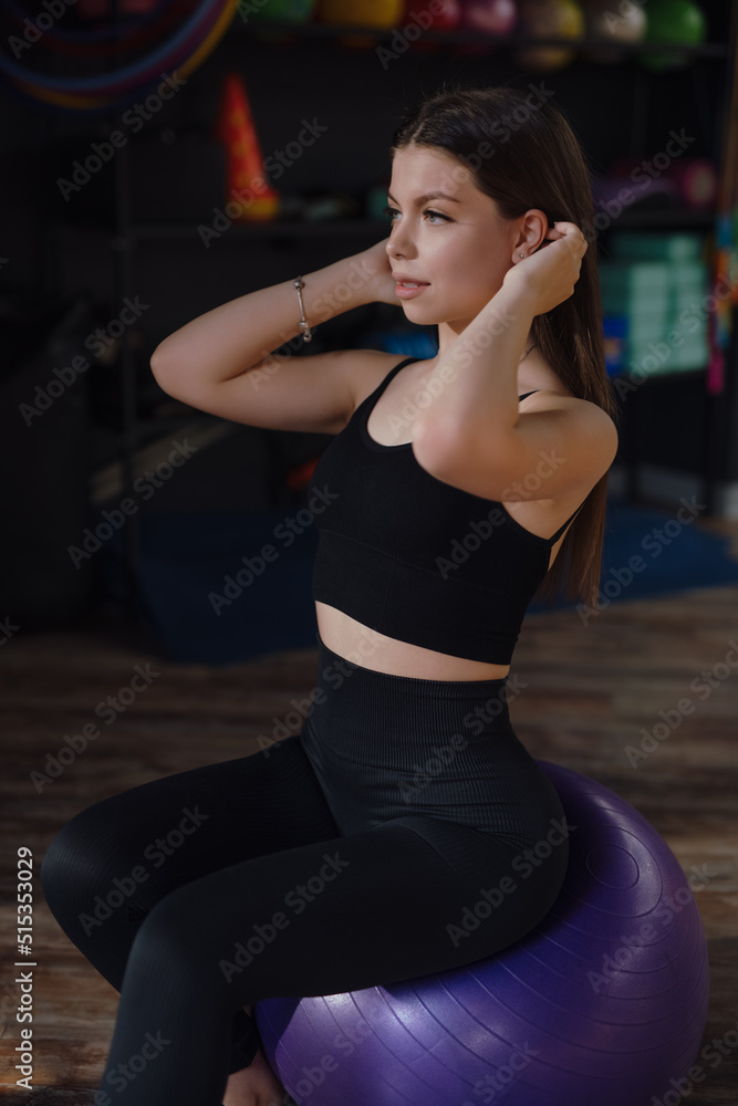Beautiful Sporty Woman Sitting On Fit Ball At The Fitness Center