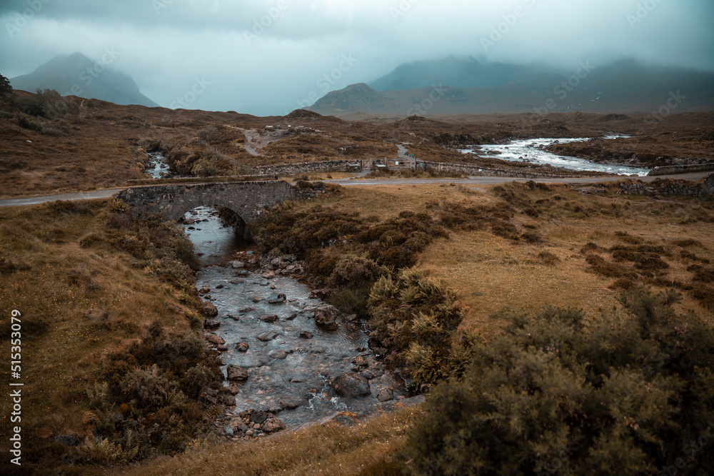 Mysterious landscape of beautiful Scotland. River flowing under stone bridge