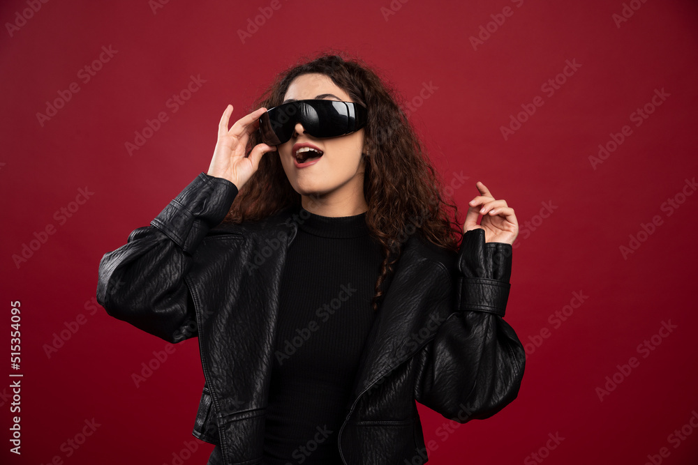 Beautiful young woman in black glasses on red background Beautiful young woman in black glasses on red background