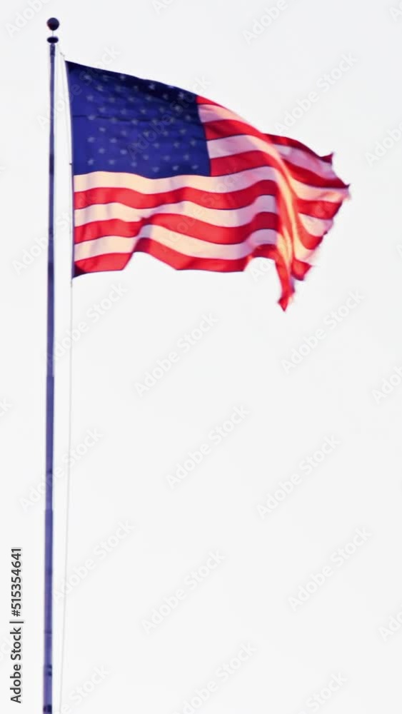 American flag on a flagpole blowing in the wind, lock down shot vertical video American flag on a flagpole blowing in the wind, lock down shot vertical video